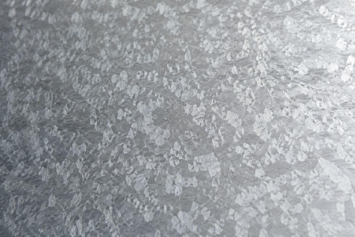 Close-up view of galvanized steel plate surface showing uniform zinc spangle pattern for roofing applications
